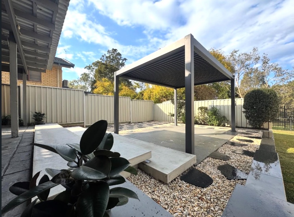 Outdoor entertainment structure featuring concrete terrace steps, potted plant, and stepping stone path
