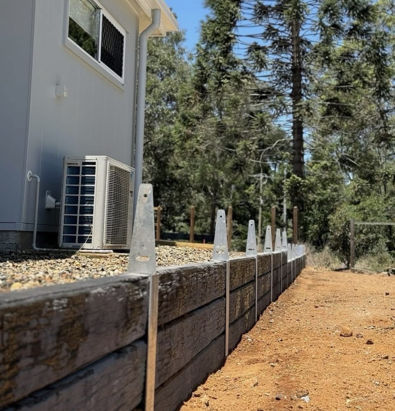 Timber sleeper retaining wall construction with galvanised steel upright posts